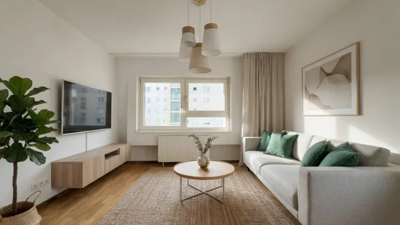 Helles Wohnzimmer mit modernem Sofa, Holzboden und Blick auf umliegende Gebäude.