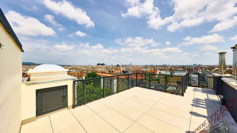 Geräumige Dachterrasse mit weitem Stadtblick und blauen Himmel, ideal zum Entspannen.