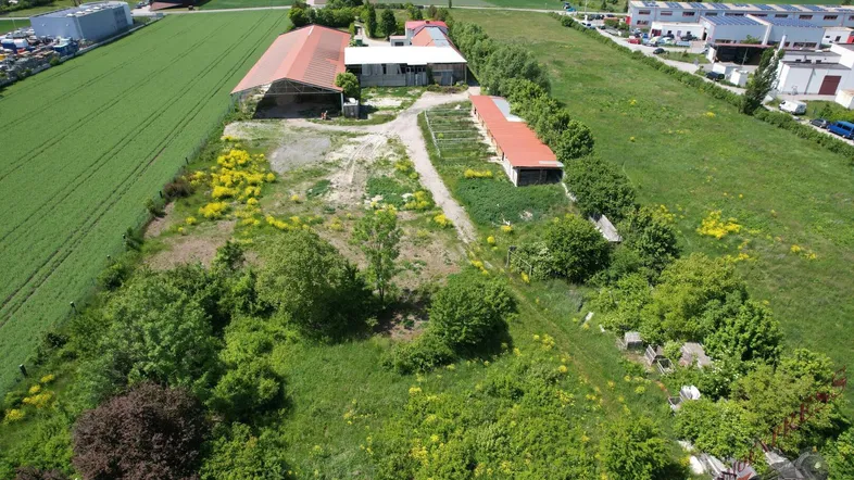 Luftaufnahme des weitläufigen Grundstücks mit mehreren Gebäuden, umgeben von Feldern und ländlicher Umgebung.