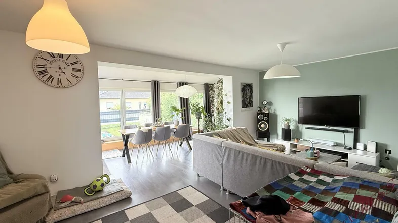 Geräumiger offener Wohn- und Essbereich mit Laminatboden und Blick in den Garten.