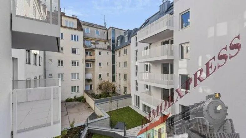 Moderne Wohngebäude mit hellen Fassaden, Balkonen und einem begrünten Innenhof.