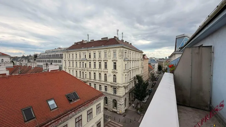 Weitläufiger Blick über die Dächer der Stadt mit historischen Gebäuden unter bewölktem Himmel.