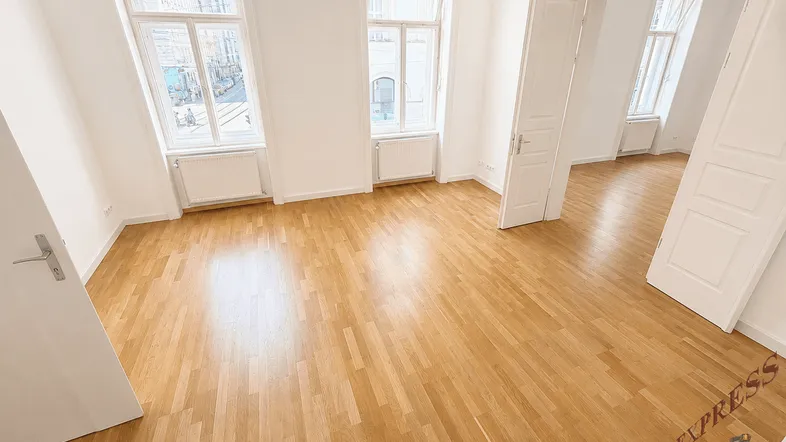 Großes, helles Zimmer mit Parkettboden und hohen Fenstern, bietet vielseitige Nutzungsmöglichkeiten.