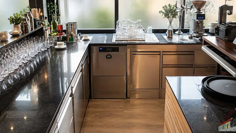Moderne Bar- und Servicebereich mit glänzenden schwarzen Arbeitsplatten und professionellen Geräten.