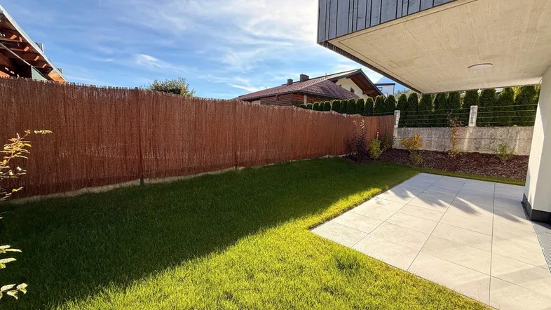 Gepflegter Garten mit Rasenfläche und blickdichtem Zaun, ideal für private Stunden im Freien.