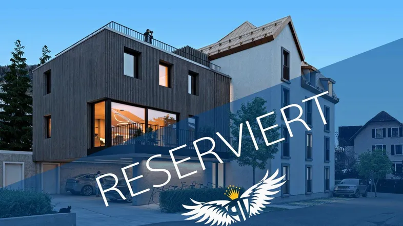 Modernes Gebäude mit dunkler Holzfassade und Dachterrasse neben einem traditionellen Altbau.