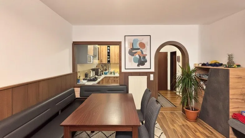 Gemütlicher Essbereich mit Holzvertäfelung, Sitzbank und Blick in die Küche sowie den Flur.