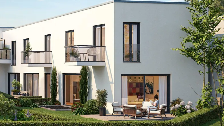 Moderne Wohnanlage mit hellen Fassaden, Balkonen und einer möblierten Terrasse im Erdgeschoss.