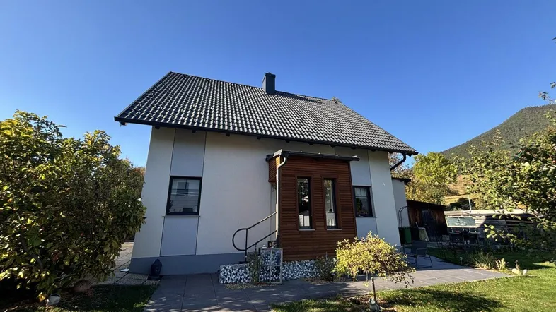 Modernes Einfamilienhaus mit Satteldach und gepflegtem Garten in ländlicher Umgebung.