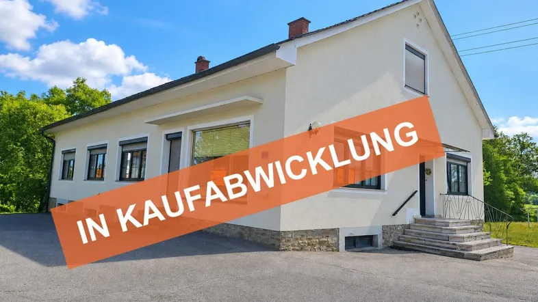 Helles Einfamilienhaus mit klassischer Architektur und einem Hinweis auf den Verkaufsstatus.