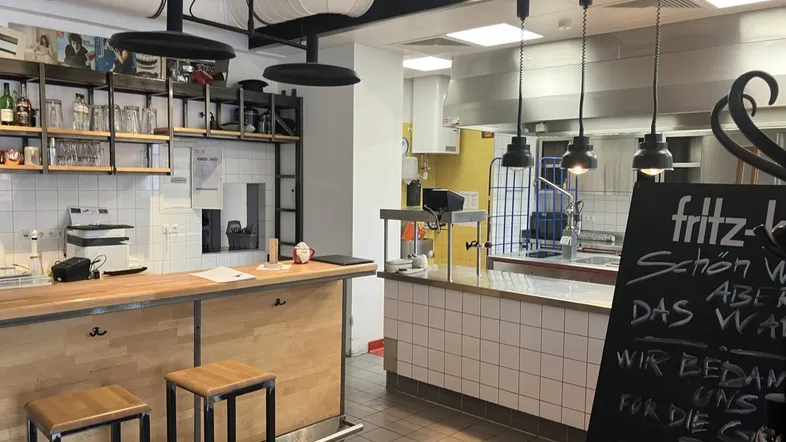 Moderne Theke und Barbereich mit industriellem Design, Blick in die professionelle Küche mit Edelstahloberflächen.