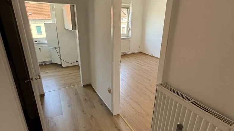 Heller Flur mit Laminatboden und Zugang zu verschiedenen Zimmern der Wohnung.