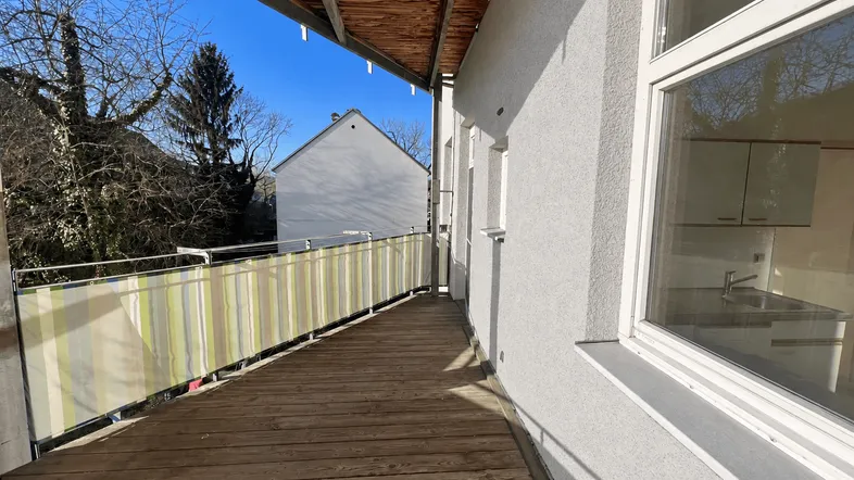 Geräumiger Balkon mit Holzboden und schützendem Sichtschutz, ideal für entspannte Stunden im Freien.
