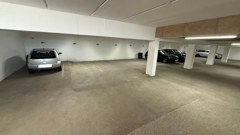 Geräumige Tiefgarage mit mehreren Stellplätzen, Betonboden und guter Beleuchtung.