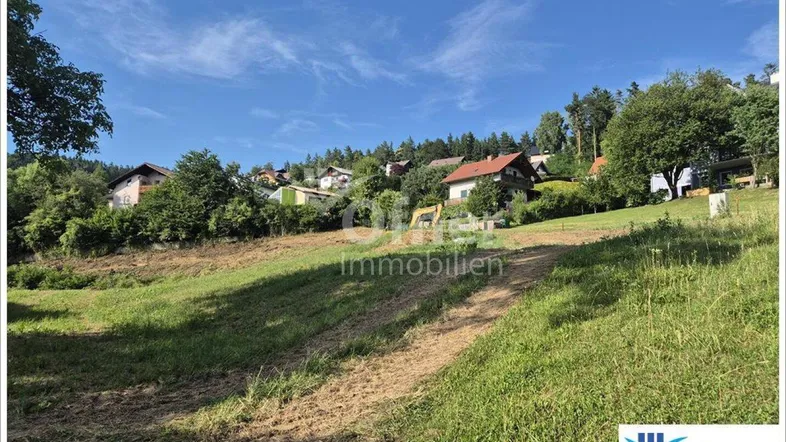 Weitläufiges Grundstück mit leichter Hanglage und Blick auf umliegende Häuser und grüne Landschaft.