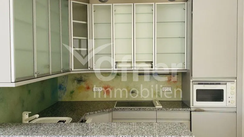 Moderne Küche mit grauen Schränken, Granitarbeitsplatte und integrierten Geräten, ideal für den täglichen Gebrauch.