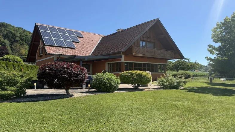 Gepflegter Gartenbereich mit Einfamilienhaus, Photovoltaikanlage und Terrasse.