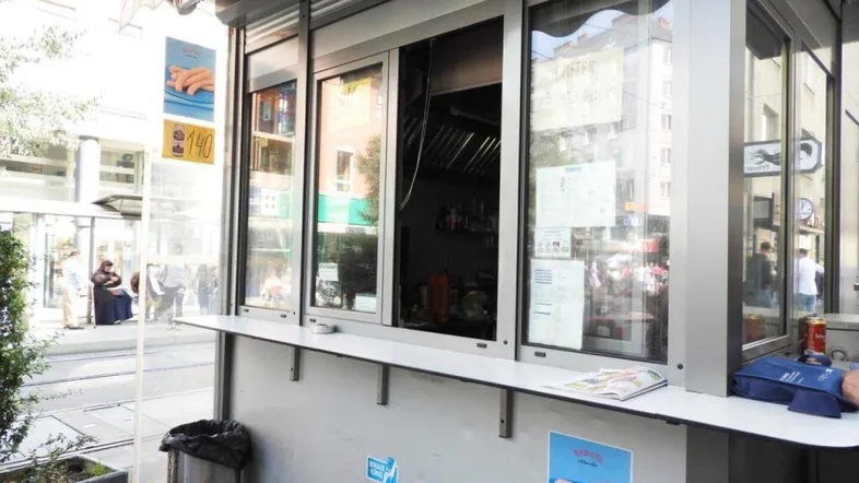 Kleiner Imbissstand mit großer Fensterfront und Theke zum Servieren an einer belebten Straße.