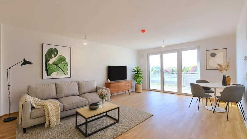 Modernes Wohn-Esszimmer mit Holzboden, Balkonzugang und stilvoller Einrichtung.