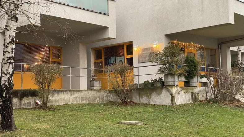 Modernes Gebäude mit großen Fenstern und einem gepflegten Rasenbereich davor.