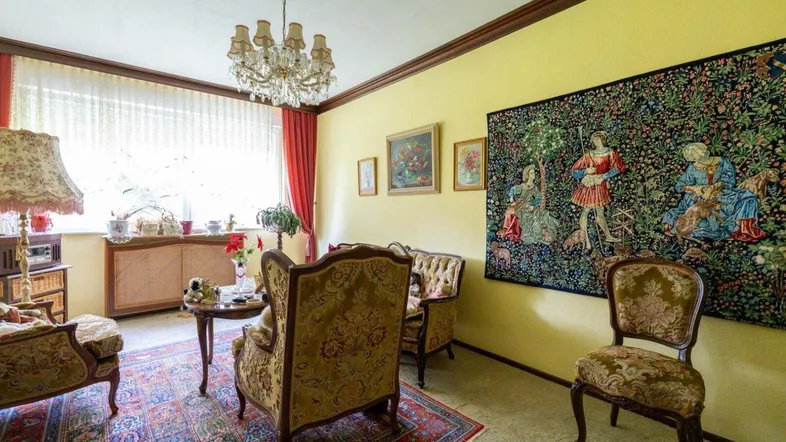 Traditionelles Wohnzimmer mit gelben Wänden, Kronleuchter und gemusterten Teppichen im Vintage-Stil.