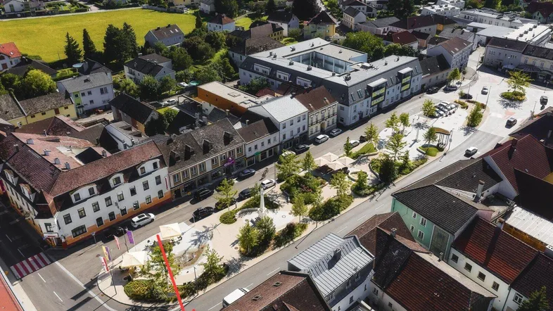 Luftaufnahme einer charmanten Kleinstadt mit Gebäuden, Straßen und Grünflächen, die das Stadtbild prägen.