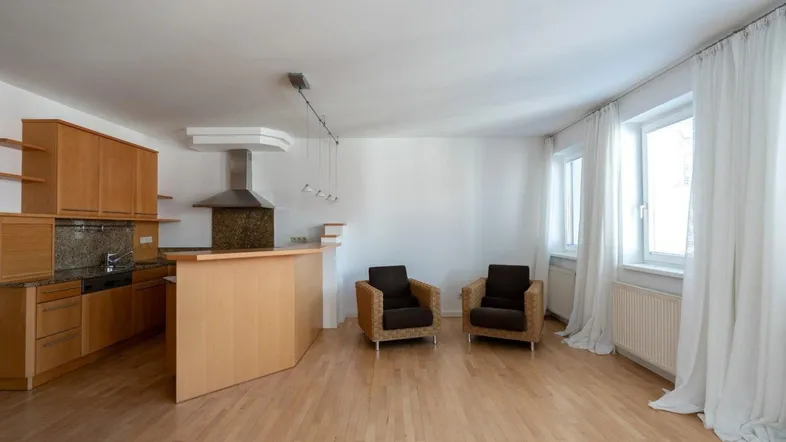 Helle Wohnküche mit Holzfronten, Granitarbeitsplatte und Barbereich in offenem Grundriss.