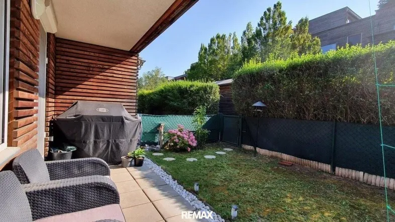 Gemütliche Terrasse mit Sitzgelegenheiten, Grillbereich und Zugang zum kleinen Garten.