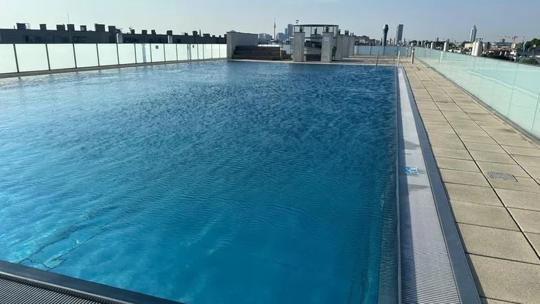Großer Dachpool mit weitem Blick über die Stadt und umliegende Gebäude.
