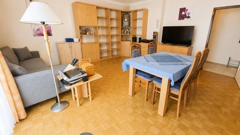 Geräumiger Wohn-Essbereich mit Parkettboden, gemütlichem Sofa und Esstisch für gesellige Runden.