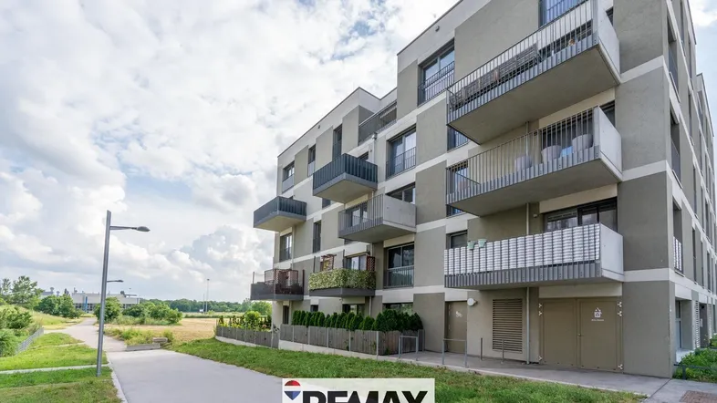 Moderne Wohnanlage mit mehreren Balkonen und zeitgenössischer Architektur unter bewölktem Himmel.