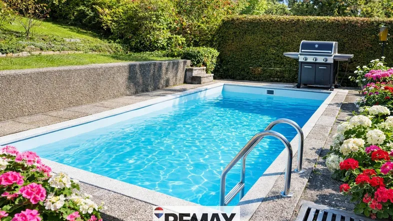 Großer Außenpool mit Grillbereich und gepflegter Grünfläche, ideal für sommerliche Entspannung und Feste.
