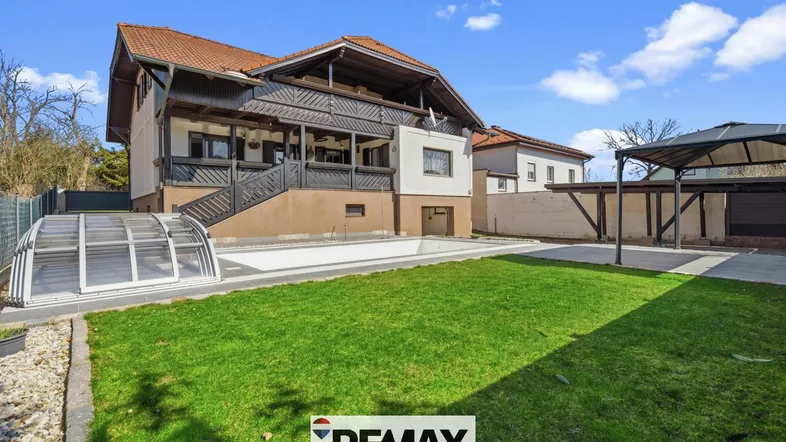 Großzügiger Gartenbereich mit Swimmingpool und Rasenfläche, ideal für Entspannung im Freien.