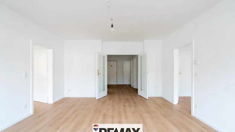 Heller, leerer Raum mit Laminatboden und weißen Wänden, bereit zur individuellen Gestaltung.
