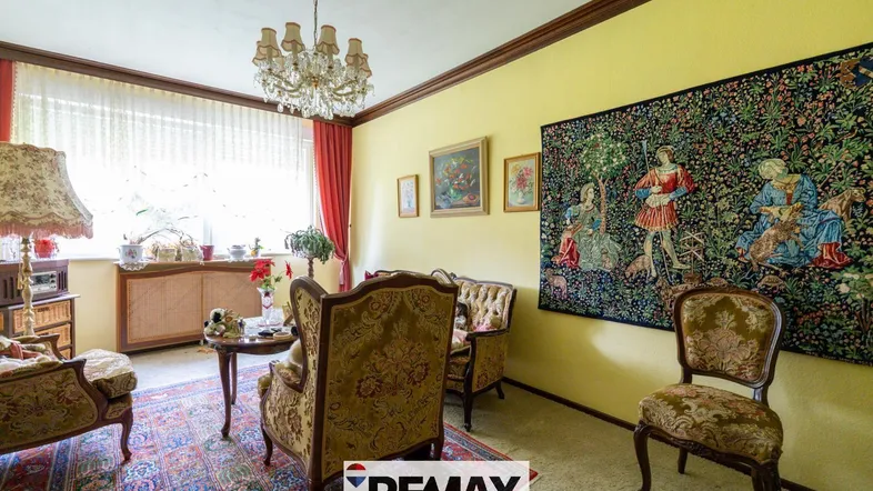 Traditionelles Wohnzimmer mit gelben Wänden, Kronleuchter und gemusterten Möbeln.