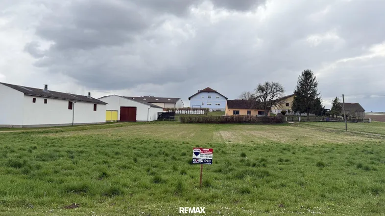 Weitläufiges Grundstück mit ländlicher Umgebung und angrenzenden Gebäuden unter bewölktem Himmel.
