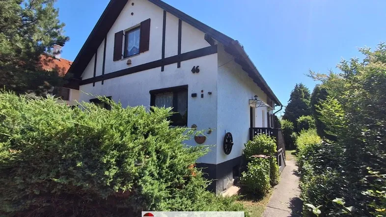 Traditionelles Einfamilienhaus mit Satteldach und gepflegter Fassade unter blauem Himmel.
