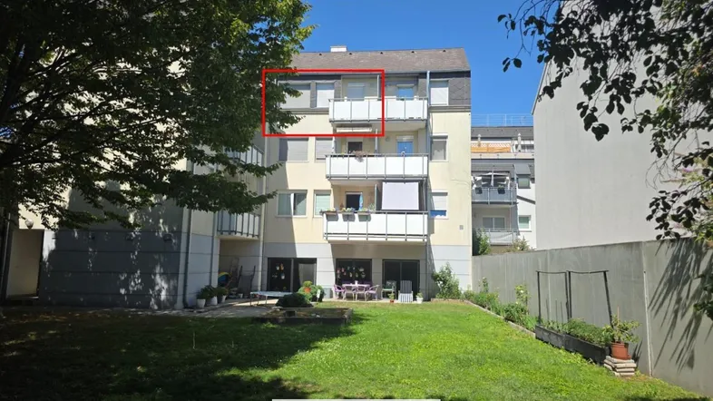 Mehrfamilienhaus mit gepflegtem Gartenbereich und Balkonen in sonniger Lage.