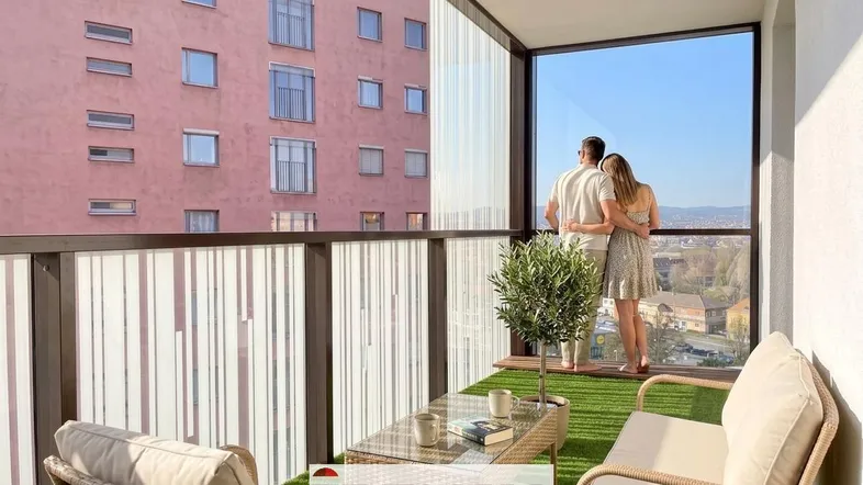 Möblierter Balkon mit Kunstrasen und weitem Blick über die Stadt, ideal zum Entspannen.