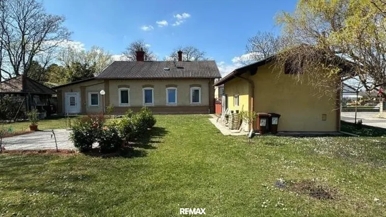 Großzügiger Gartenbereich vor dem Haus mit Rasenfläche und Sträuchern.