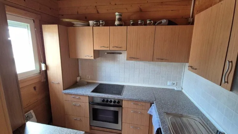Rustikale Küche mit Holzvertäfelung, Einbauschränken und integrierten Geräten.