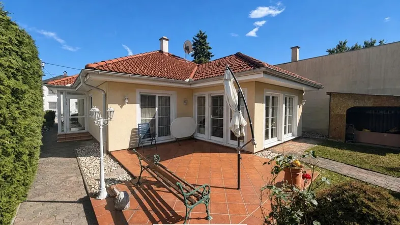 Großzügige Terrasse mit Sitzgelegenheiten und Blick auf den Garten, umgeben von gepflegter Hecke.