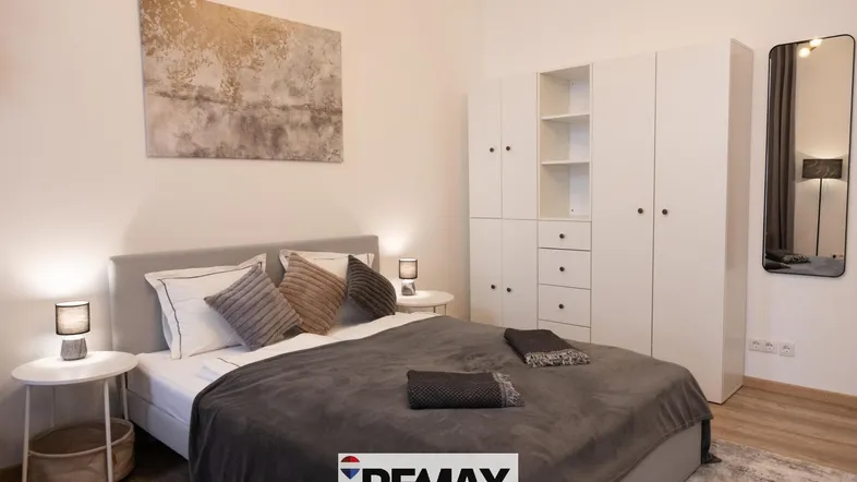 Helles Schlafzimmer mit großem Bett, modernem Kleiderschrank und stilvoller Dekoration.