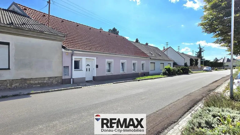 Blick auf die Fassade des Hauses und die ruhige Wohnstraße mit weiteren Gebäuden.