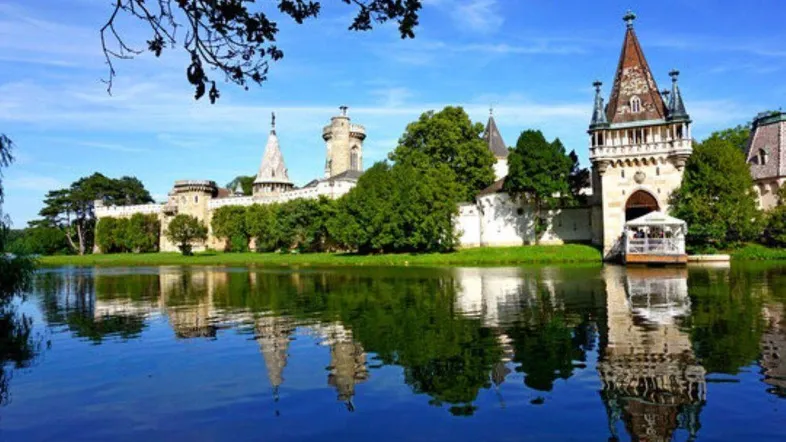 Malerisches Schlossgebäude am Seeufer mit beeindruckender Architektur und Spiegelung im Wasser.