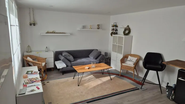 Helles Wohnzimmer mit modernem Sofa, Couchtisch und hellem Bodenbelag, ideal zum Entspannen.