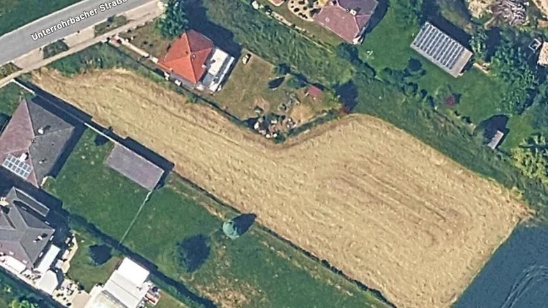 Luftaufnahme eines Grundstücks mit umliegenden Häusern und einer Straße in ländlicher Umgebung.