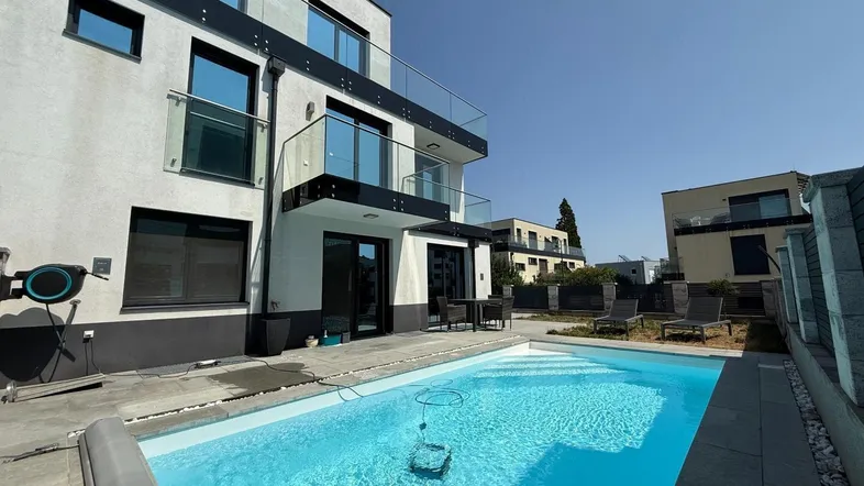 Moderner Neubau mit privatem Pool und Terrasse, ideal für Entspannung im Freien an sonnigen Tagen.
