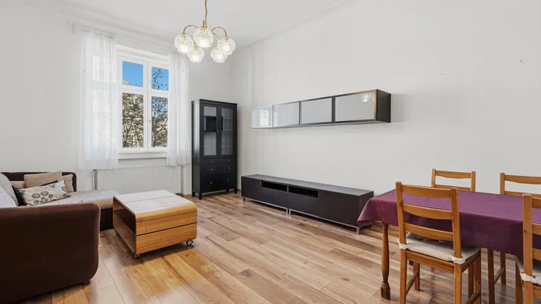 Helles Wohn- und Esszimmer mit Holzboden, Sofa und Esstisch, ideal für geselliges Beisammensein.