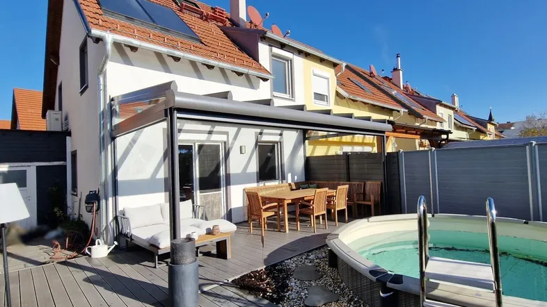 Große Holzterrasse mit Essbereich, Lounge-Möbeln und Whirlpool, ideal für Entspannung im Freien.